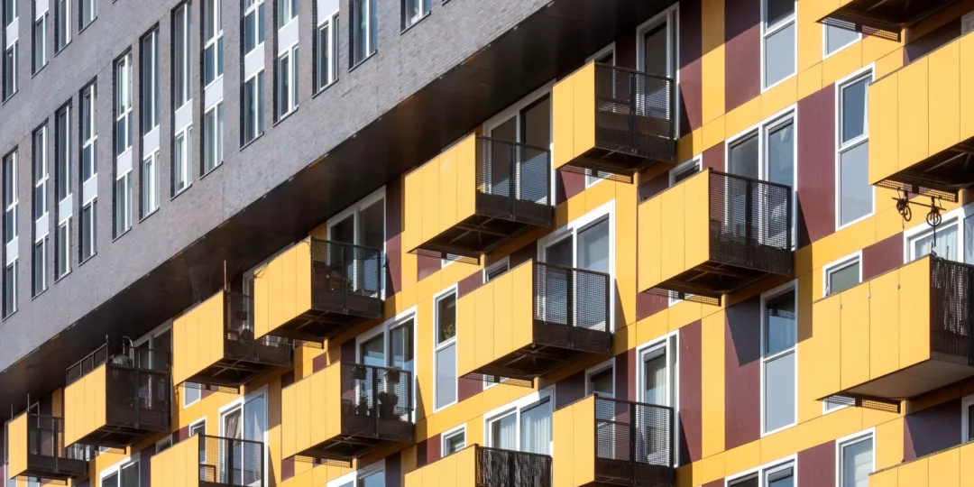 Façade d'immeuble avec balcons colorés en jaune et rouge — indivision