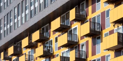 Façade d'immeuble avec balcons colorés en jaune et rouge — indivision