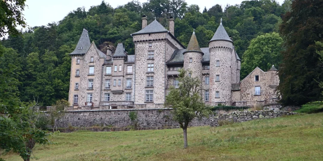 Château en pierre avec tours et fenêtres sur un terrain verdoyant — chateau