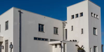 Bâtiment moderne aux murs blancs sous un ciel bleu — Amancio Ortega