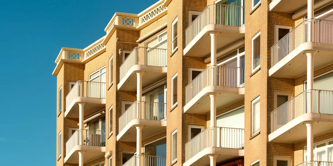Façade d'immeuble moderne avec balcons et ciel bleu — logement
