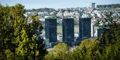 Trois immeubles modernes entourés d'arbres et de collines — Clermont-Ferrand