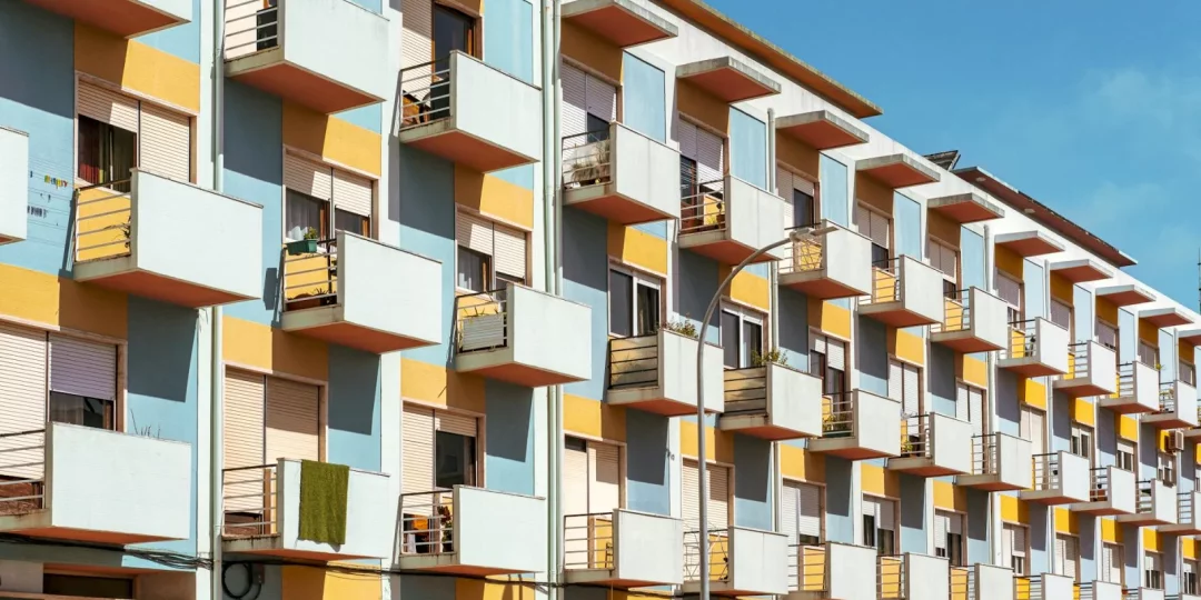 Immeuble moderne avec balcons colorés sous un ciel bleu — colocation