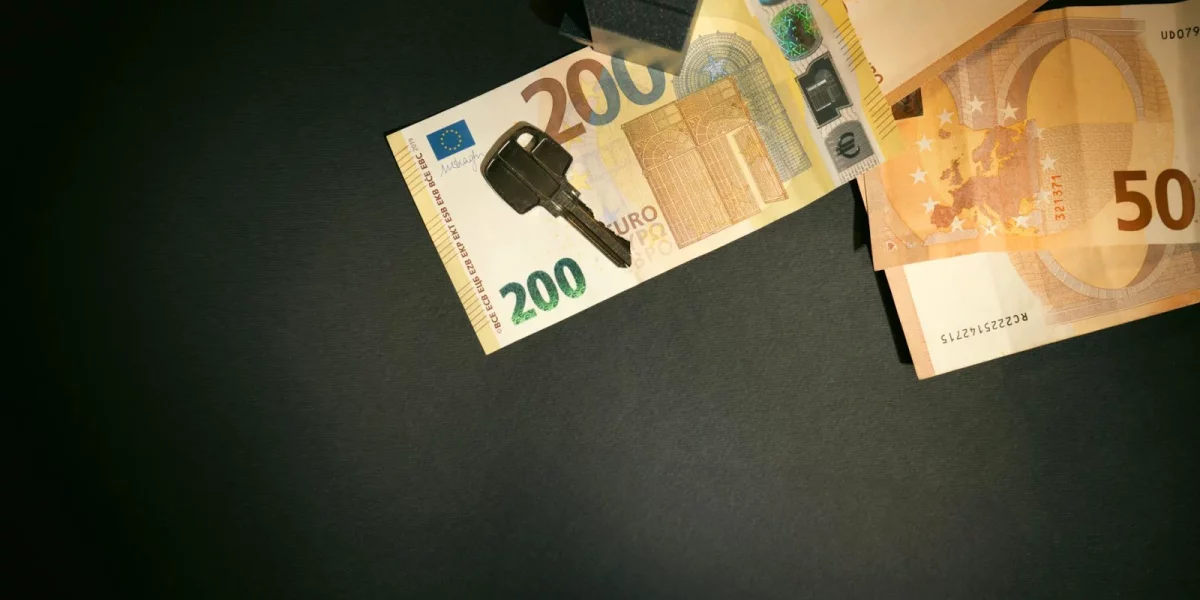 Billets de banque et clé sur une surface sombre — credit immobilier fonctionnaire