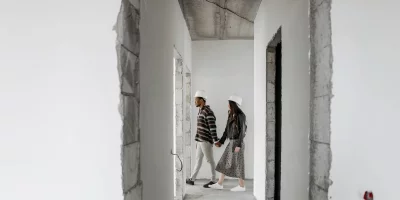Couple marchant dans un couloir de chantier avec casques de sécurité — MaPrimeRénov