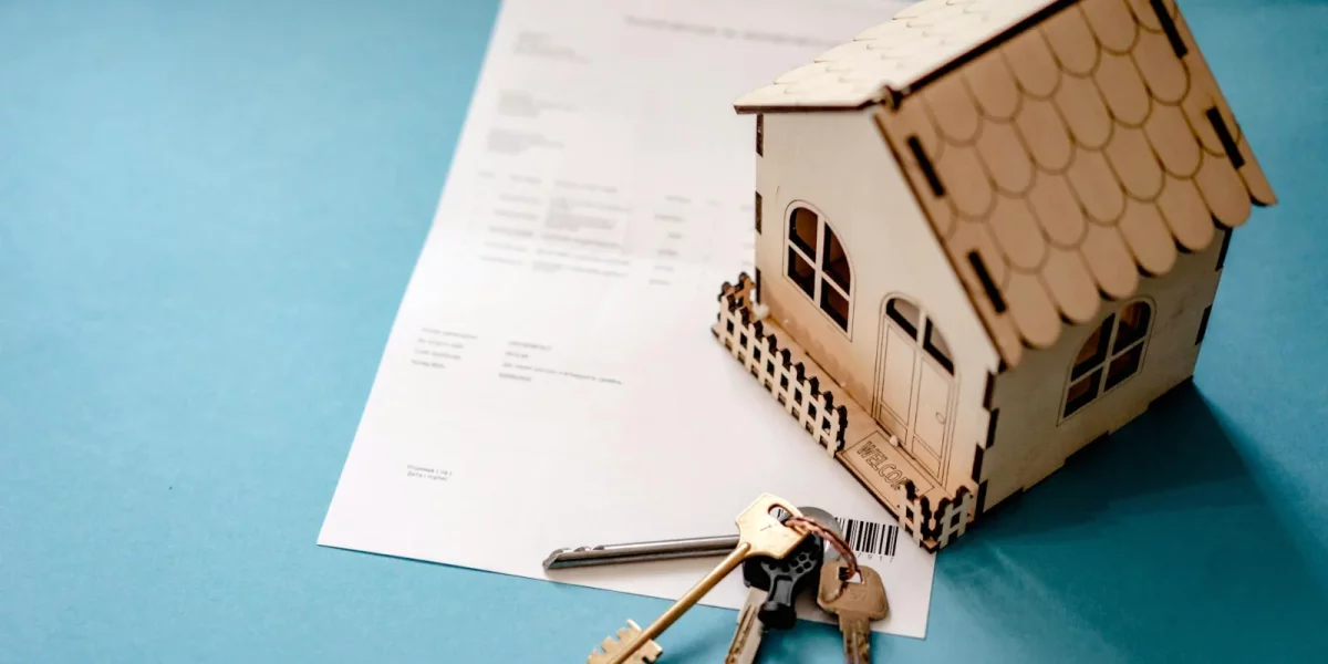 Maison en bois miniature avec des clés et un document — droits de succession neveu