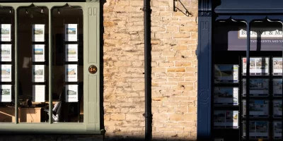 Vitrines d'agences immobilières avec annonces affichées — transmission