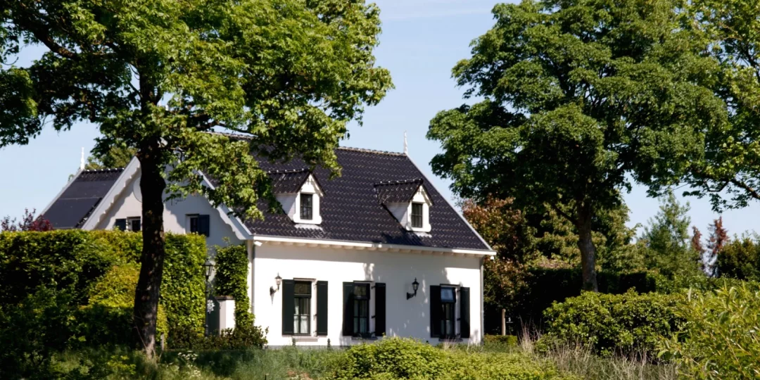 Maison avec un jardin verdoyant et des arbres autour — frais succession maison