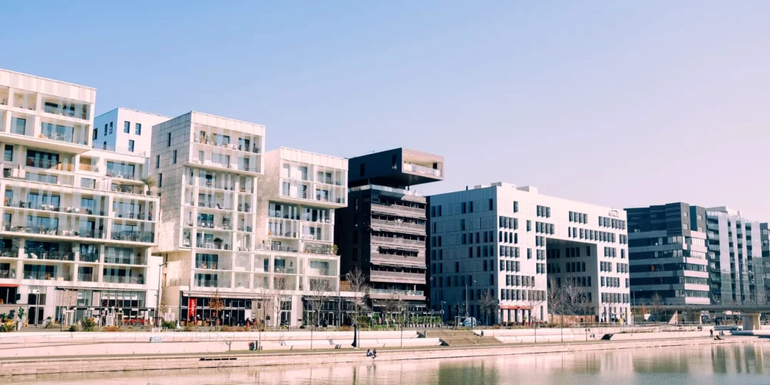 Immeubles modernes au bord de l'eau sous un ciel bleu — investissement-locatif