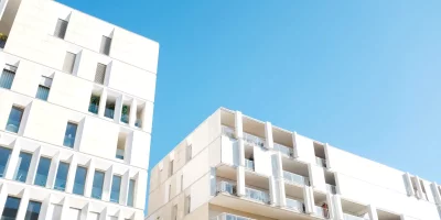 Immeubles modernes sous un ciel bleu clair — investissement locatif LMNP