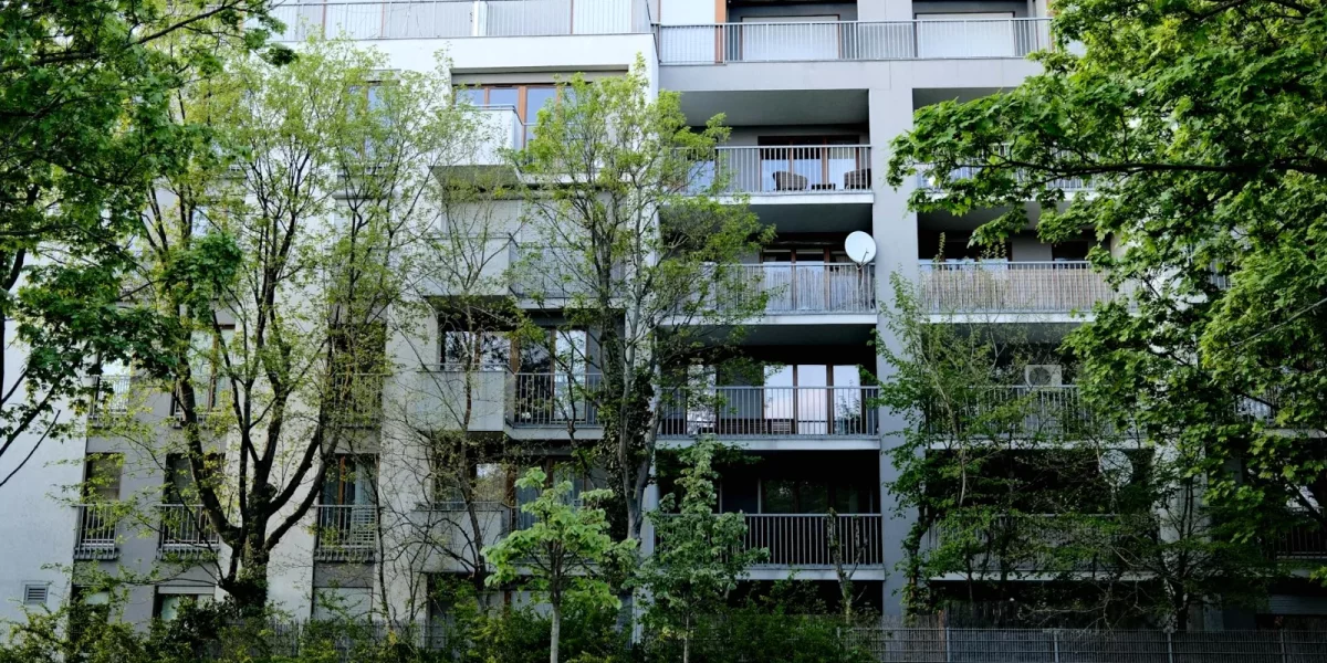 Immeuble moderne entouré d'arbres avec balcons — investissement-locatif