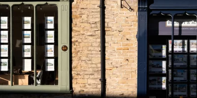 Vitrine d'agence immobilière avec annonces affichées — signer un mandat de vente