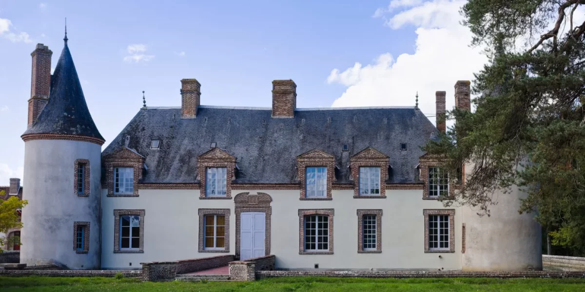 Manoir avec tourelle et fenêtres à petits carreaux sous un ciel bleu — Montretout