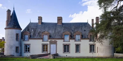 Manoir avec tourelle et fenêtres à petits carreaux sous un ciel bleu — Montretout