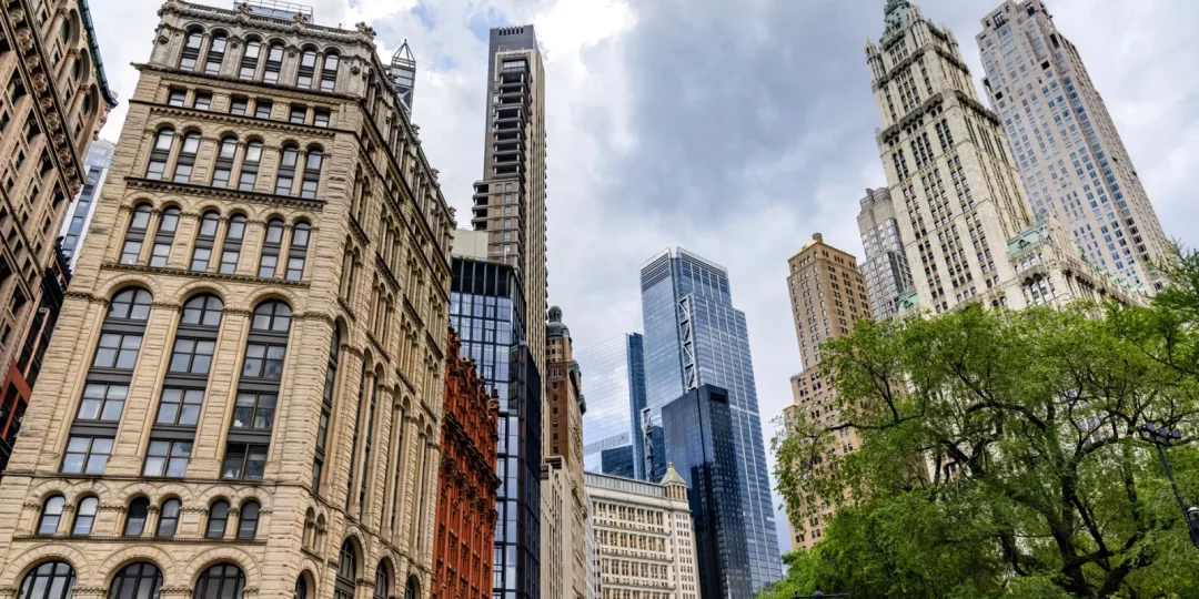 Gratte-ciels modernes et bâtiments historiques sous un ciel nuageux — New York