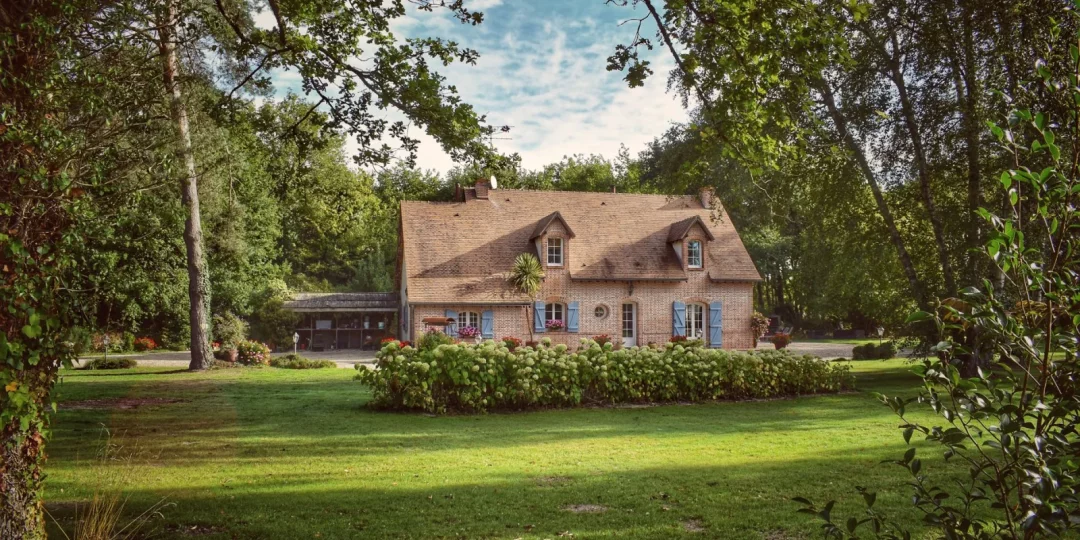 Maison en briques entourée d'un jardin verdoyant — plus-value résidence secondaire