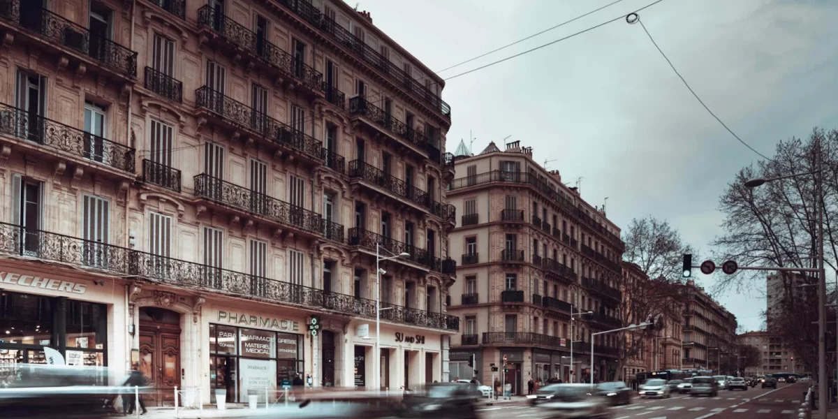 Rue animée avec des bâtiments anciens et des voitures en mouvement — commerce