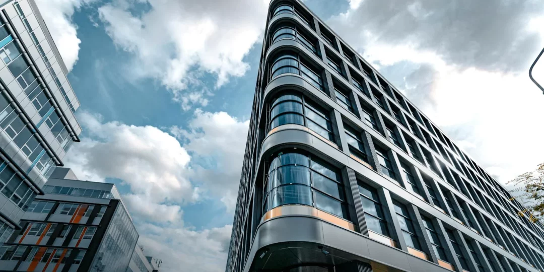 Immeuble moderne avec façade en verre sous un ciel nuageux — datacenters
