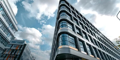 Immeuble moderne avec façade en verre sous un ciel nuageux — datacenters