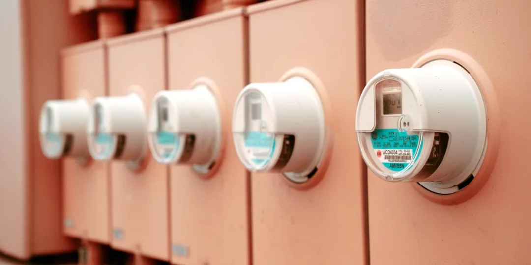 Compteurs d'électricité alignés sur un mur en extérieur — electricite