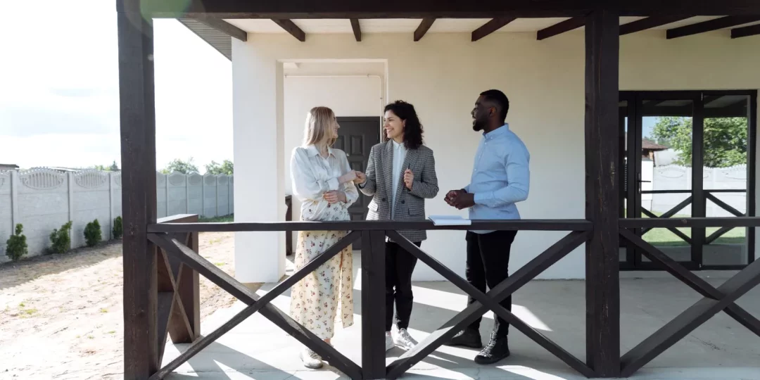 Trois personnes discutant sur une terrasse devant une maison — indivision