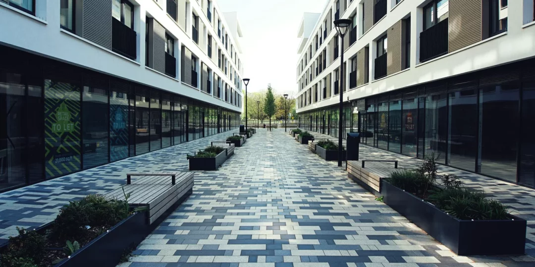 Allée pavée entre deux bâtiments modernes avec plantations — servitude de passage