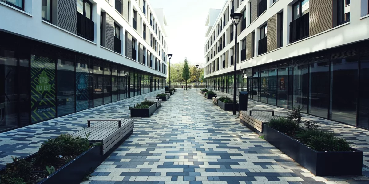 Allée pavée entre deux bâtiments modernes avec plantations — servitude de passage