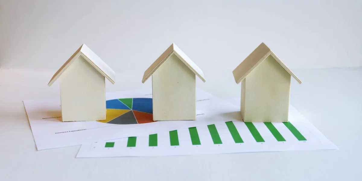Modèles de maisons en papier sur un graphique de croissance — taux