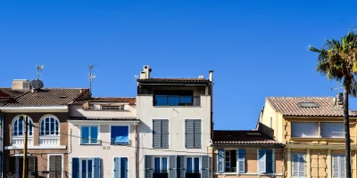 Immeubles colorés avec balcons et ciel bleu — taxe foncière 2026