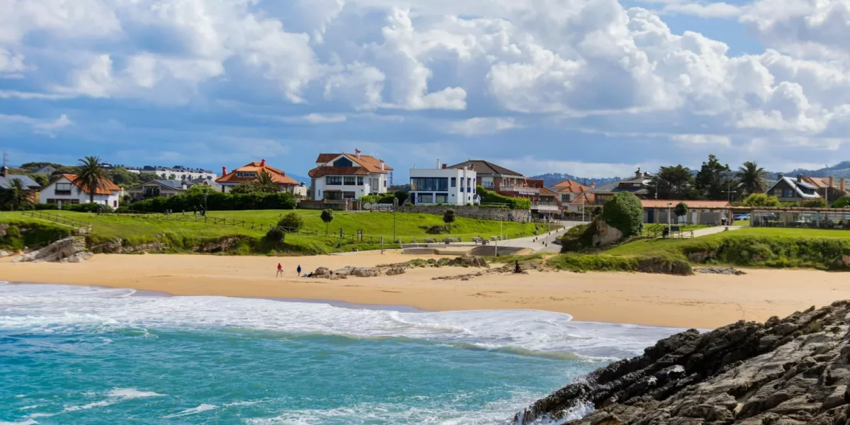 Plage avec maisons en arrière-plan et ciel nuageux — immobilier anglet