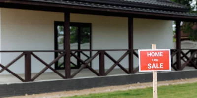 Panneau "Home for Sale" devant une maison avec véranda — vendre sa maison rapidement